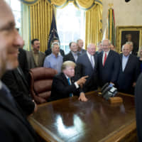 President Donald Trump, accompanied by Agriculture Secretary Sonny Perdue *left), gestures as he answers a question from a reporter during a meeting to support America\'s farmers and ranchers in the Roosevelt Room of the White House Thursday in Washington. | AP