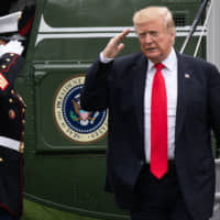 U.S. President Donald Trump salutes as he walks from Marine One after arriving on the South Lawn of the White House in Washington on Friday following a one-night trip to New York. | AFP-JIJI