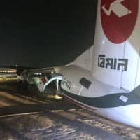 This handout picture taken and released by Myanmar Department of Civil Aviation on Wednesday shows a Biman Bangladesh airlines passenger plane after it slid off a runway at Yangon International airport in Yangon. Eleven people were injured as a plane slid off the runway, police said, as a freak storm hit the city. | HANDOUT / MYANMAR DEPARTMENT OF CIVIL AVIATION / VIA AFP-JIJI