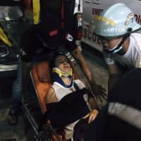 Myanmar rescue members help an injured passenger in Yangon International airport Wednesda. A plane operated by Biman Bangladesh Airlines skidded off the runway while landing Wednesday evening at Myanmar\'s Yangon International Airport. | AP