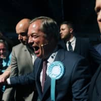 Brexit Party leader Nigel Farage (center) shakes hands with his supporters Tuesday during a Brexit Party rally in London. The European Parliament elections have never been so hotly anticipated or contested, with many predicting this year\'s ballot will mark a coming-of-age moment for the euroskeptic far-right movement. The elections start Thursday. | AP