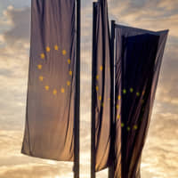 European flags blow in front of the European Central Bank as the sun rises in Frankfurt on Sunday. | AP