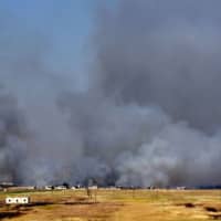 Smoke billows above buildings in the town of Kafr Nabuda in the north of the Syrian Hama province during reported airstrikes by Syrian regime forces on Sunday. | AFP-JIJI