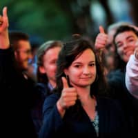 People make the thumbs-up as a gesture in support of pro-life as they take part in a white march Monday in Paris from the Ministry of health to the Elysee Palace to ask for a presidential pardon for Vincent Lambert, a quadriplegic man who has been in a vegetative state for the last decade. | AFP-JIJI