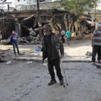 A Syrian man whose shop was destroyed in a regime aerial bombardment the previous day walks around the area on May 15 in Jisr al-Shughur in Syria\'s jihadist-held Idlib province. | AFP-JIJI