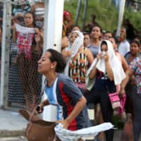 Relatives of inmates react in front of a prison complex in the Brazilian state of Amazonas after prisoners were found strangled to death in four separate jails, according to the penitentiary department in Manaus on Monday. | REUTERS