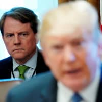 White House Counsel Don McGahn sits behind U.S. President Donald Trump as the president holds a Cabinet meeting at the White House in Washington last June. | REUTERS