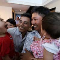 Reuters reporters Wa Lone and Kyaw Soe Oo celebrate with their children after being freed from prison, after receiving a presidential pardon in Yangon on Tuesday. | POOL / VIA REUTERS