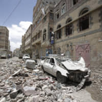 People inspect the site of an airstrike by Saudi-led coalition forces in Sanaa Thursday,. Yemen\'s human rights minister says heavy fighting is underway in the country\'s south as rebel Houthis push to gain more territory from government forces and their allies. The clashes come as the Saudi-led coalition carried out airstrikes on the capital earlier on Thursday, targeting the Houthis and killing at least three civilians. | AP