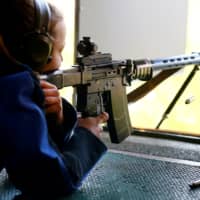 A cartridge case is ejected as a woman fires her rifle at a target 300 meters away at the shooting range of the Schuetzenverein Ossingen rifle club in Ossingen, Switzerland, on Thursday. In a referendum held Sunday, Swiss voters agreed to adopt tighter gun controls in line with changes to European Union rules. | REUTERS