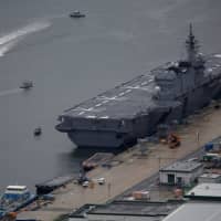 The Kaga, a Maritime Self-Defense Force Izumo-class helicopter carrier, is moored at a naval base in Sasebo, Nagasaki Prefecture, in April last year. | REUTERS