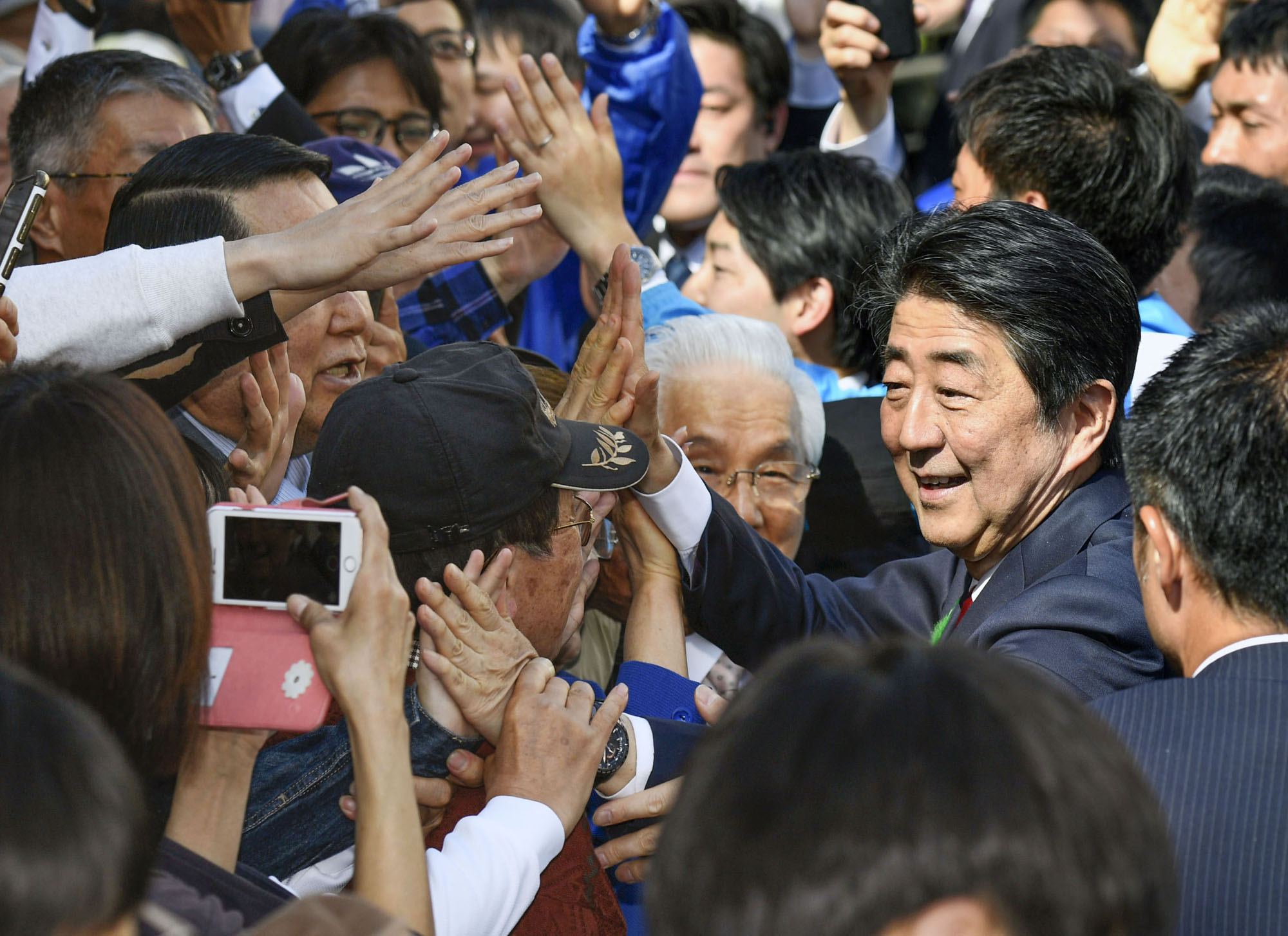 Prime Minister Shinzo Abe greets people after delivering a speech in Osaka in April ahead of Lower House by-elections. | KYODO