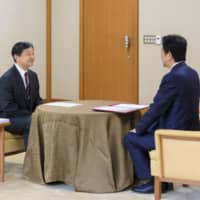 Emperor Naruhito receives his first briefing on domestic and international matters from Prime Minister Shinzo Abe at the Imperial Palace in Tokyo on Tuesday. | IMPERIAL HOUSEHOLD AGENCY / VIA KYODO