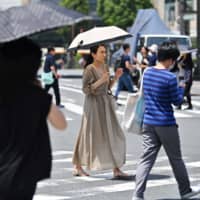People cross a street in Tokyo\'s Ginza district on Monday amid high temperatures. | AFP-JIJI