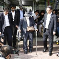 Kozo Iizuka exits Mejiro Police Station in Tokyo on Saturday. Iizuka had been discharged from hospital earlier in the day and was later questioned by police about a fatal car crash in Ikebukuro last month in which two people died. | KYODO