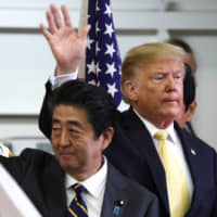 Prime Minister Shinzo Abe and U.S. President Donald Trump wave after delivering speeches to Japanese and U.S. forces aboard the Maritime Self-Defense Force\'s Kaga helicopter carrier at the MSDF base in Yokosuka, Kanagawa Prefecture, on Tuesday. | REUTERS
