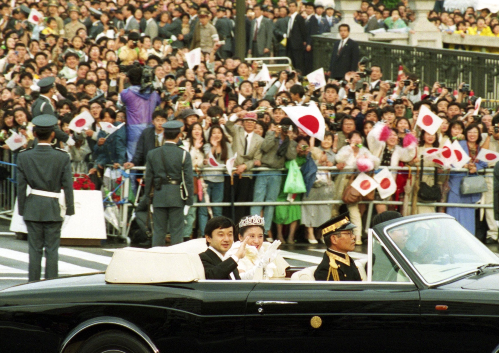 Crown Prince Naruhito and Crown Princess Masako wave during a wedding parade in Tokyo in June 1993. | KYODO