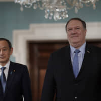 Chief Cabinet Secretary Yoshihide Suga arrives with U.S. State Secretary Mike Pompeo on May 9 at the State Department in Washington. | AP