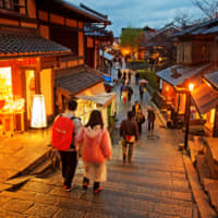 Tourists walk on a street leading to Kiyomizu Temple in Kyoto in November 2013. The number of foreign visitors to Japan hit a record high in April. | GETTY IMAGES