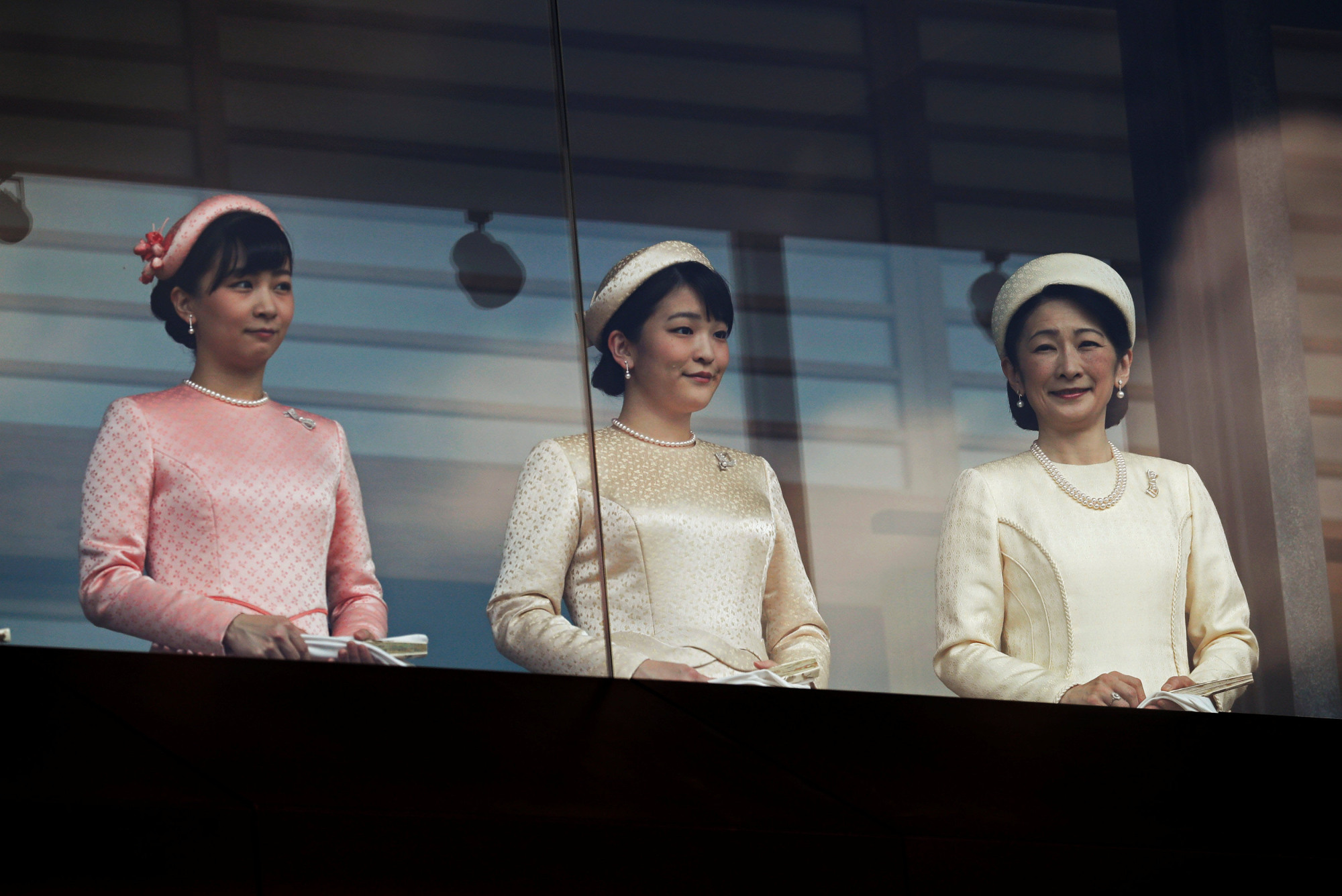 Crown Princess Kiko (right) and her daughters, Princess Mako (center) and Princess Kako, greet well-wishers during a public appearance at the Imperial Palace in Tokyo on Saturday. | REUTERS