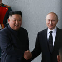 North Korean leader Kim Jong Il and Russian President Vladimir Putin pose for photographers before holding a summit on Russky Island near Vladivostok on April 25. | BLOOMBERG
