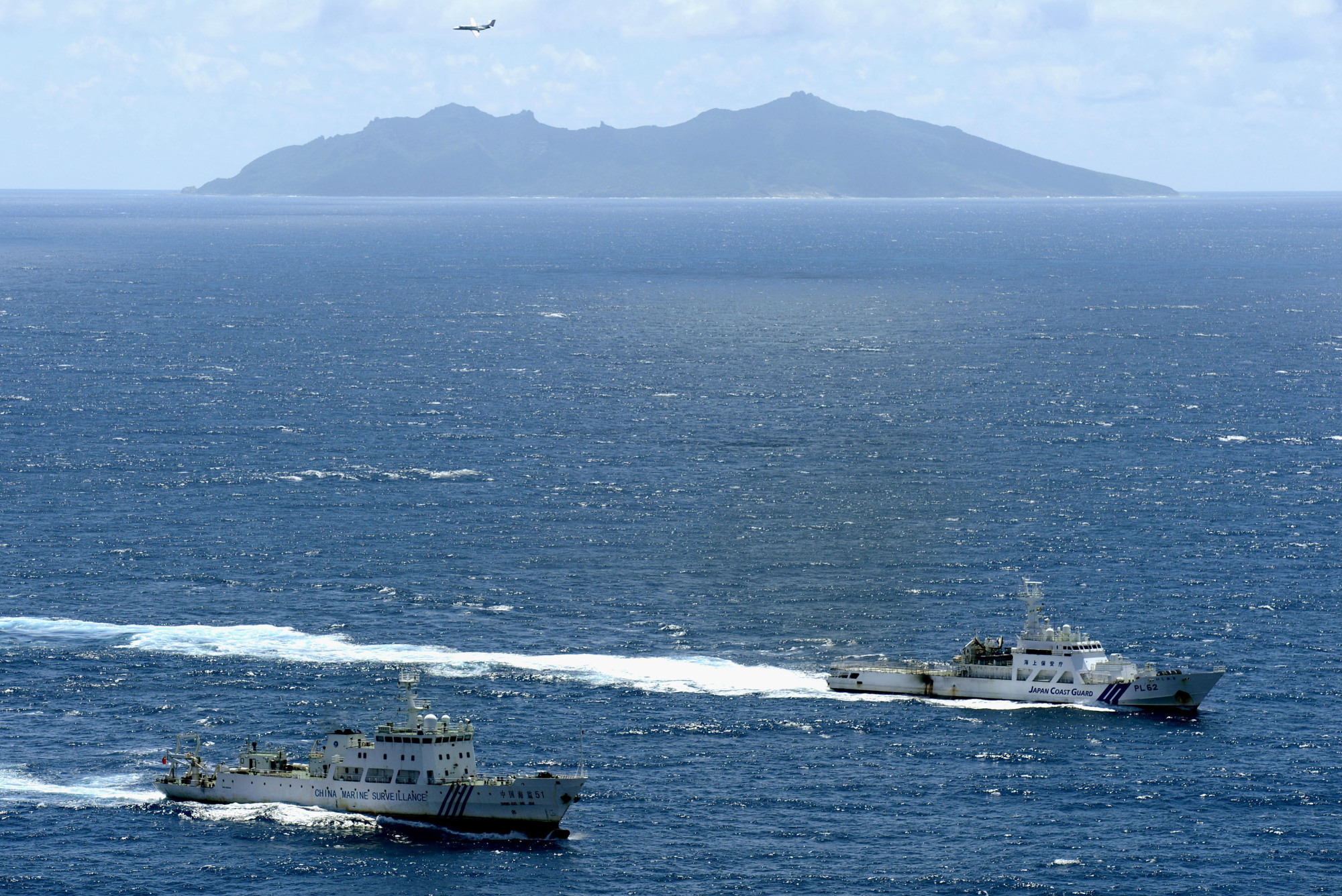 A Japan Coast Guard ship (right) and a Chinese surveillance ship sail in Japanese waters off the northeastern coast of Uotsuri, one of the five main islets in the Senkaku Islands chain, on Sept. 14, 2012. The territorial dispute has been a flash point in Japan-China relations since 2012 when the Japanese government nationalized the uninhabited islets. | KYODO