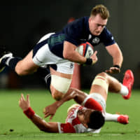 Stuart Hogg falls on Japan\'s Hendrik Tui during a match at Ajinomoto Stadium in 2016. | AFP-JIJI