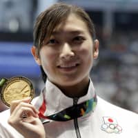 Japan\'s Rikako Ikee holds up her gold medal after winning the women\'s 50-meter freestyle final during the swimming competition at the 18th Asian Games in Jakarta last August. | A