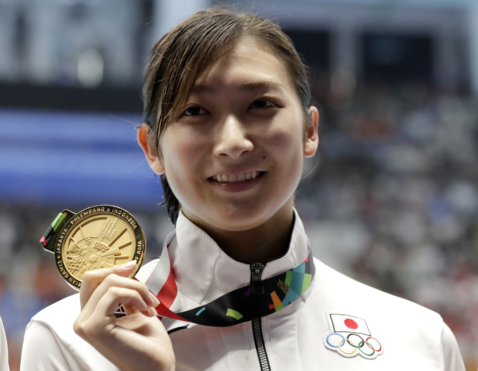 Japan's Rikako Ikee holds up her gold medal after winning the women's 50-meter freestyle final during the swimming competition at the 18th Asian Games in Jakarta last August. | A