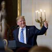 U.S. President Donald Trump gives a thumbs up during a Celebration of Military Mothers event on Friday in Washington. Trump is expected to present a trophy to the winner of the Summer Basho on May 26 at Ryogoku Kokugikan. | BLOOMBERG