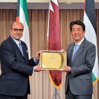 The Dean of the Council of Arab Ambassadors in Japan and Palestinian Ambassador Waleed Siam (left) presents a memorial gift to Prime Minister Shinzo Abe. | MIKI OSHITA