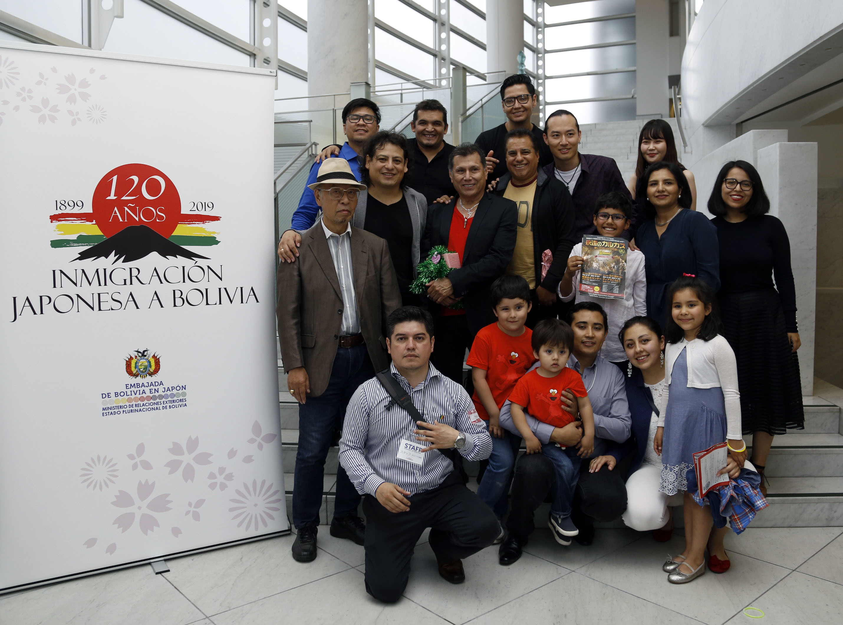 Los Kjarkas poses with Angela Karin Ayllon Quisbert, Bolivian charge d'affaires ad interim (center row, second from right); Hidejiro Mimura, president of the association of cultural exchange between Latin America and Japan (center row, left); and members of the Bolivian embassy staff with family. | PHOTO COURTESY OF BOLIVIA EMBASSY