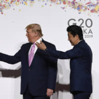 President Donald Trump Prime Minister Shinzo Abe motion for White House adviser Jared Kushner and his wife Ivanka Trump to join them as they arrive at the G-20 summit in Osaka on Friday. | AP