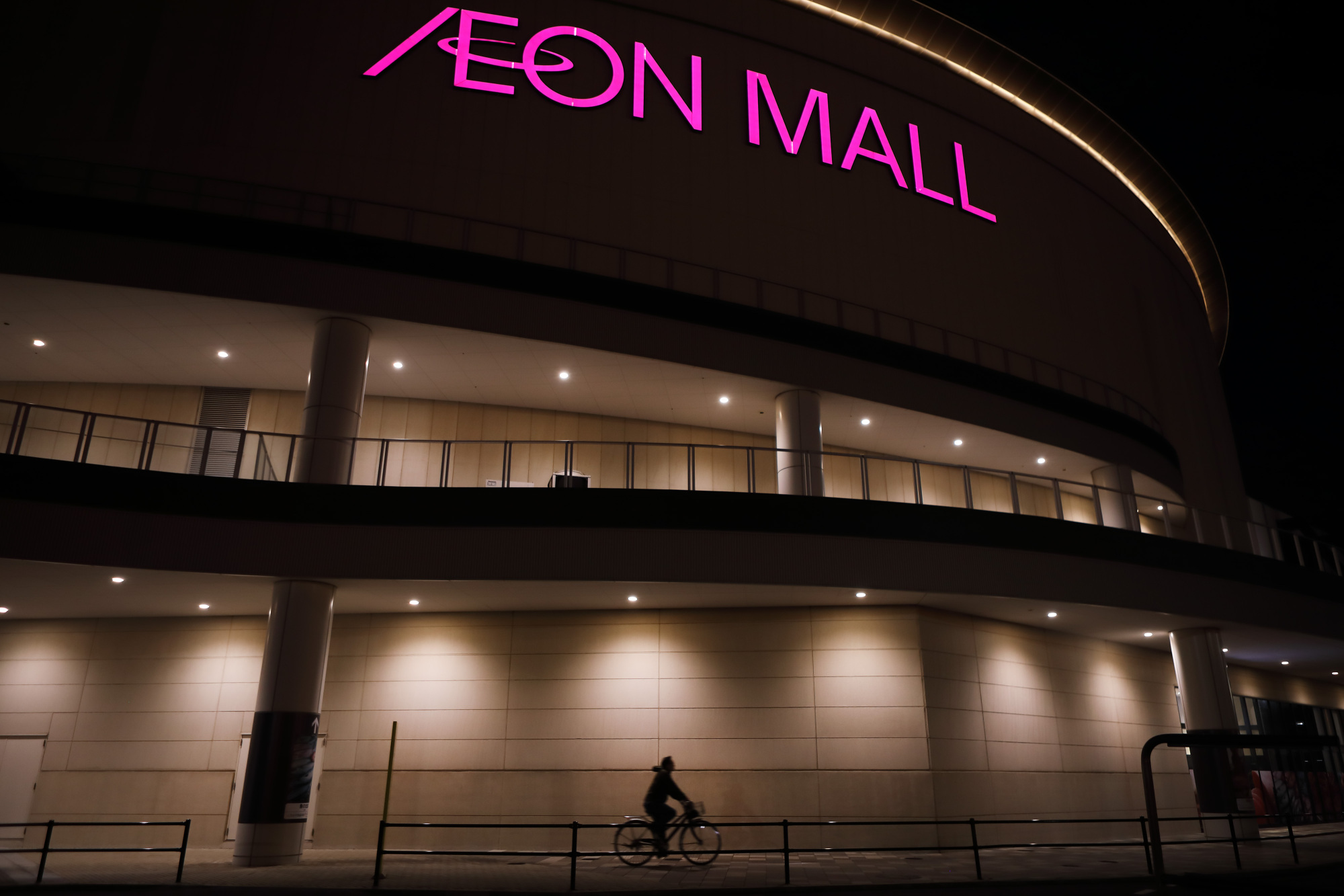 A woman rides past an Aeon shopping mall in Chiba in January 2018. | BLOOMBERG