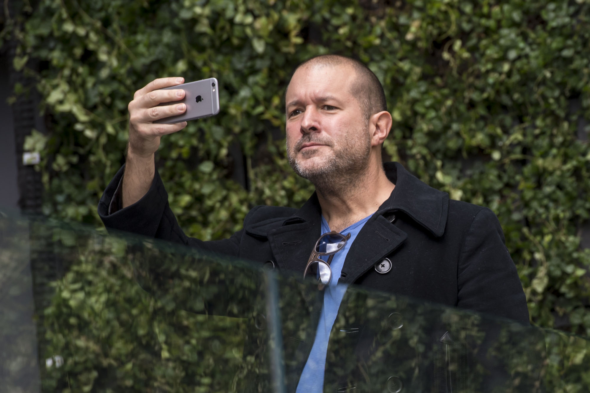 Jonathan 'Jony' Ive, chief design officer for Apple Inc., uses an iPhone to take a photograph during the grand opening of the company's new flagship store at Union Square in San Francisco in May 2016. | BLOOMBERG