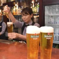 A bartender serves Heineken beer in Tokyo on Tuesday. Heineken Kirin K.K. expects demand for beer to surge during the Rugby World Cup due to the many fans who are due to visit from overseas to watch the tournament. | KYODO