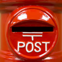 A replica post box is displayed at the Japan Post Holdings Co. headquarters in Tokyo in January last year. The company plans to set a limit on over-the-counter international cash transfers of ¥5 million ($46,000) to combat money laundering, sources close to the matter said Tuesday. | BLOOMBERG