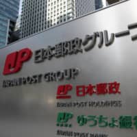 A signboard of Japan Post Group, consisting of Japan Post Bank, Japan Post Insurance and Japan Post, is seen in November 2018. | KYODO