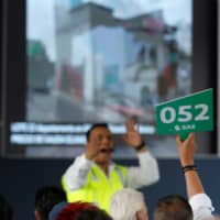 A man bids during an auction of seized properties from drug traffickers and others, in Mexico City Sunday. | REUTERS