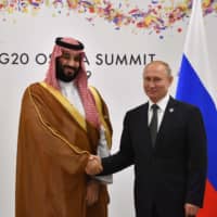 Russian President Vladimir Putin shakes hands with Saudi Arabian Crown Prince Mohammed bin Salman during a meeting on the sidelines of the G20 summit in Osaka on Saturday. | AFP-JIJI