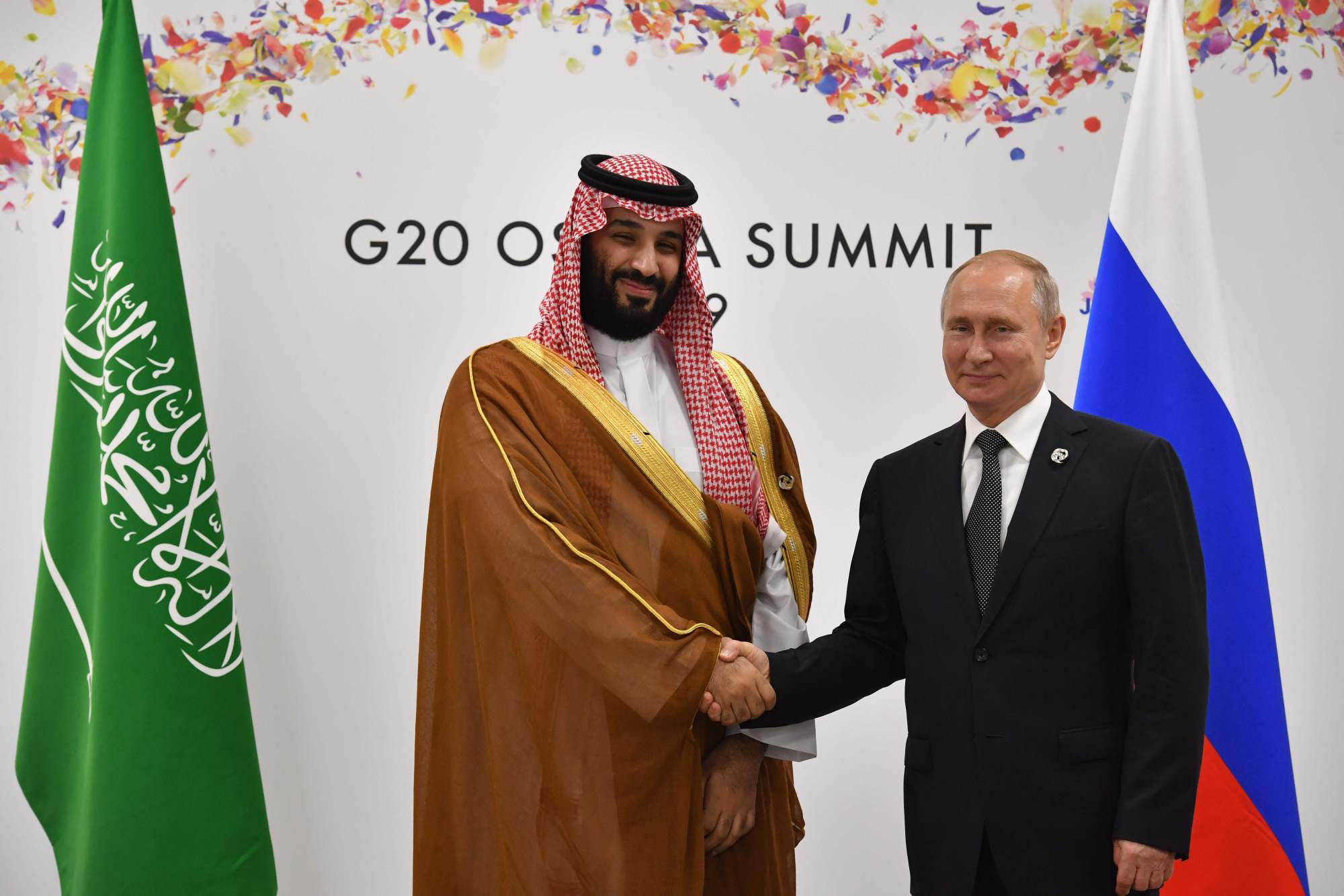 Russian President Vladimir Putin shakes hands with Saudi Arabian Crown Prince Mohammed bin Salman during a meeting on the sidelines of the G20 summit in Osaka on Saturday. | AFP-JIJI