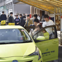 Passengers enter a taxi in Otaru in Hokkaido. | KYODO