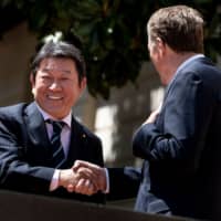 Minister of Economic Revitalization Toshimitsu Motegi (left) and U.S. Trade Representative Robert Lighthizer shake hands before a meeting at the Office of the U.S. Trade Representative in Washington on April 16. | AFP-JIJI