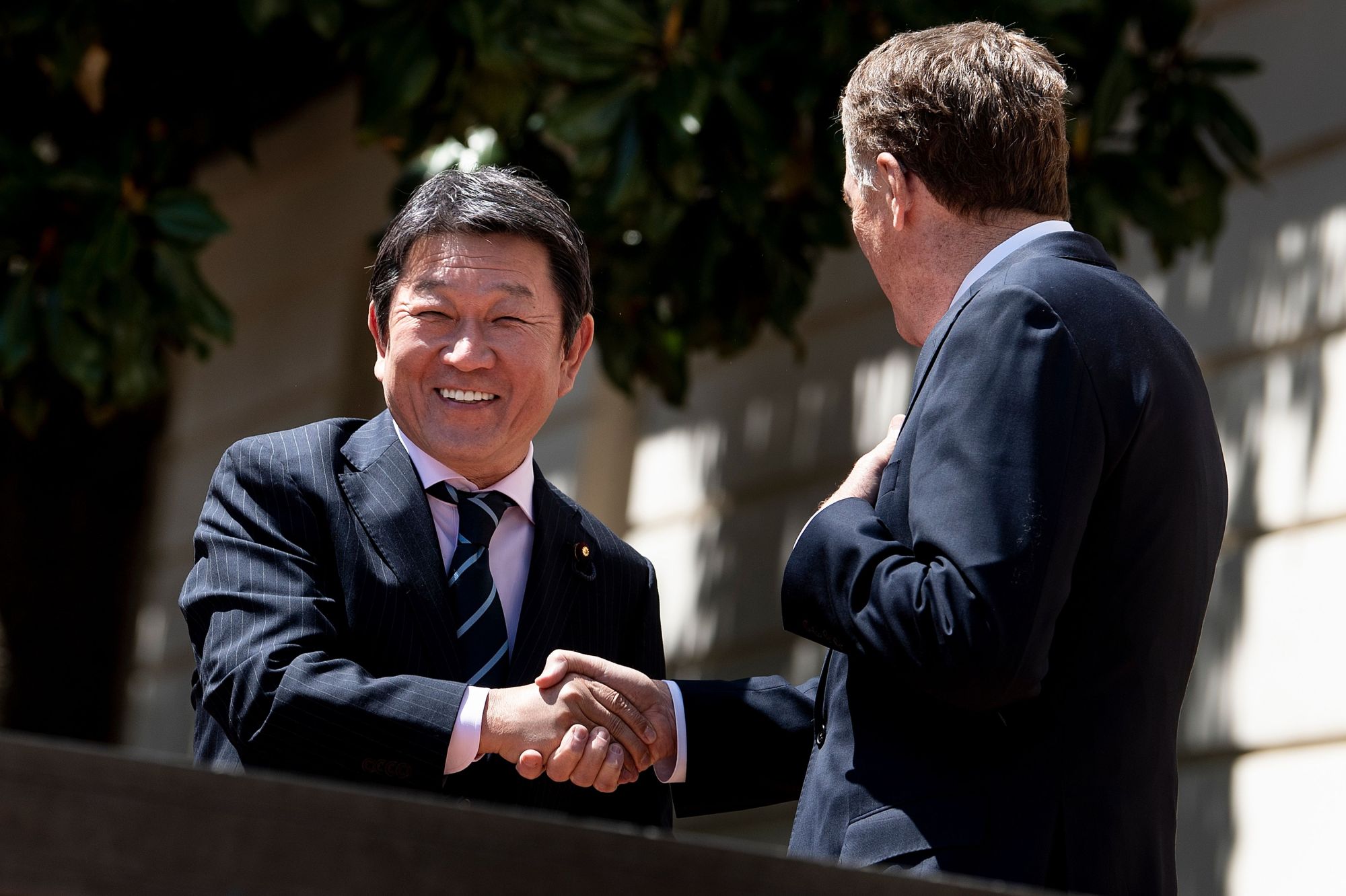 Minister of Economic Revitalization Toshimitsu Motegi (left) and U.S. Trade Representative Robert Lighthizer shake hands before a meeting at the Office of the U.S. Trade Representative in Washington on April 16. | AFP-JIJI