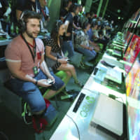 Gaming fans play Bleeding Edge at the Xbox E3 2019 Showcase in the Microsoft Theater at L.A. Live on Sunday in Los Angeles. Premier game event E3 kicked off on Tuesday. | CASEY RODGERS/INVISION/AP