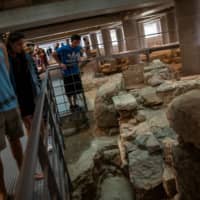 People visit the newly opened archaeological site underneath the Acropolis Museum in Athens on Friday. | REUTERS