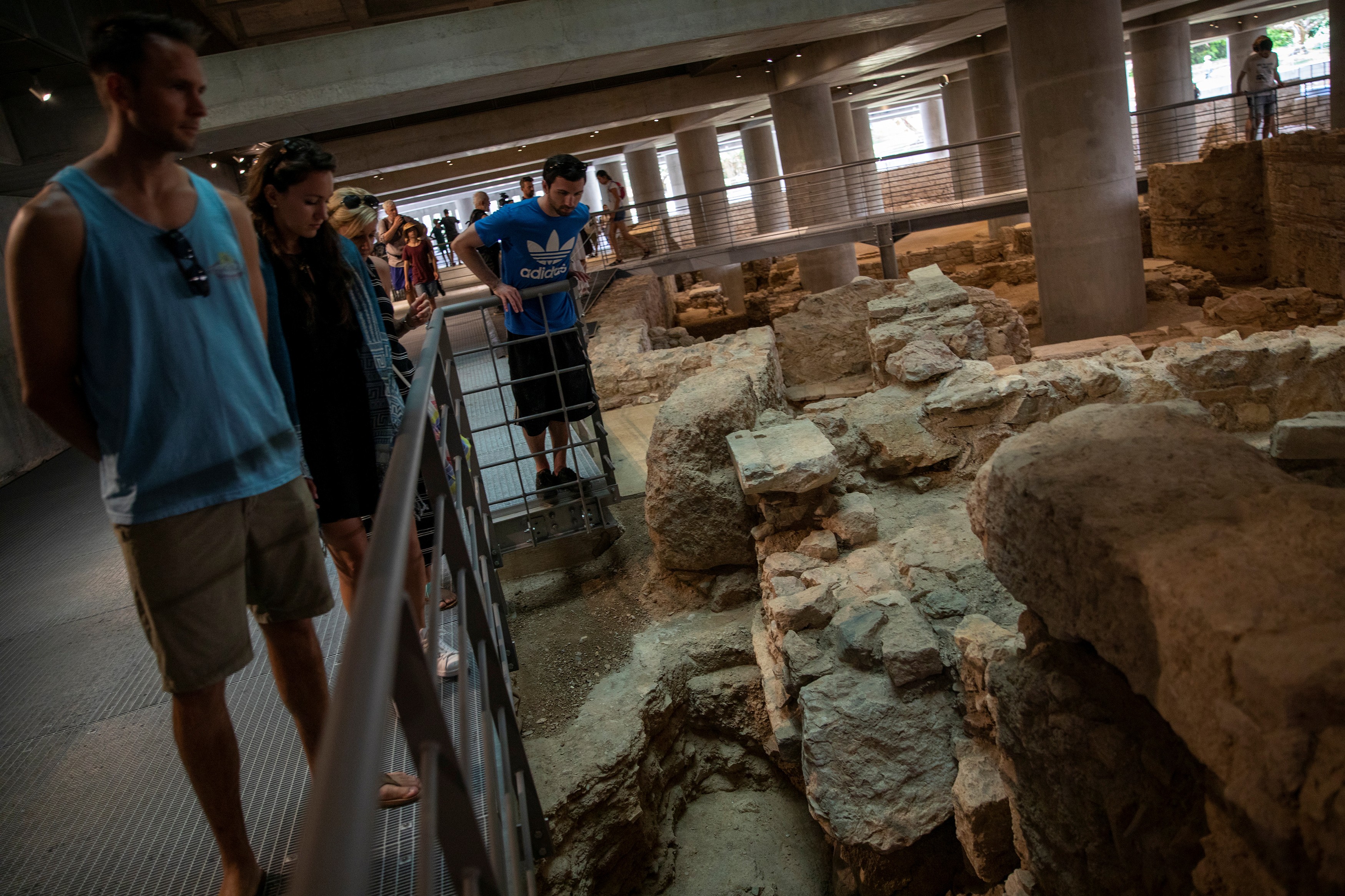 People visit the newly opened archaeological site underneath the Acropolis Museum in Athens on Friday. | REUTERS