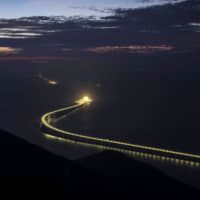 Artificial islands are illuminated at dusk on the 55 km Hong Kong-Zhuhai-Macao Bridge in Hong Kong in October. | BLOOMBERG