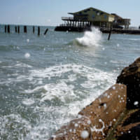 The rising waters of the Gulf of Mexico crash at the shoreline of the Treasure Island community of West Galveston Island, Texas, in 2014. | REUTERS