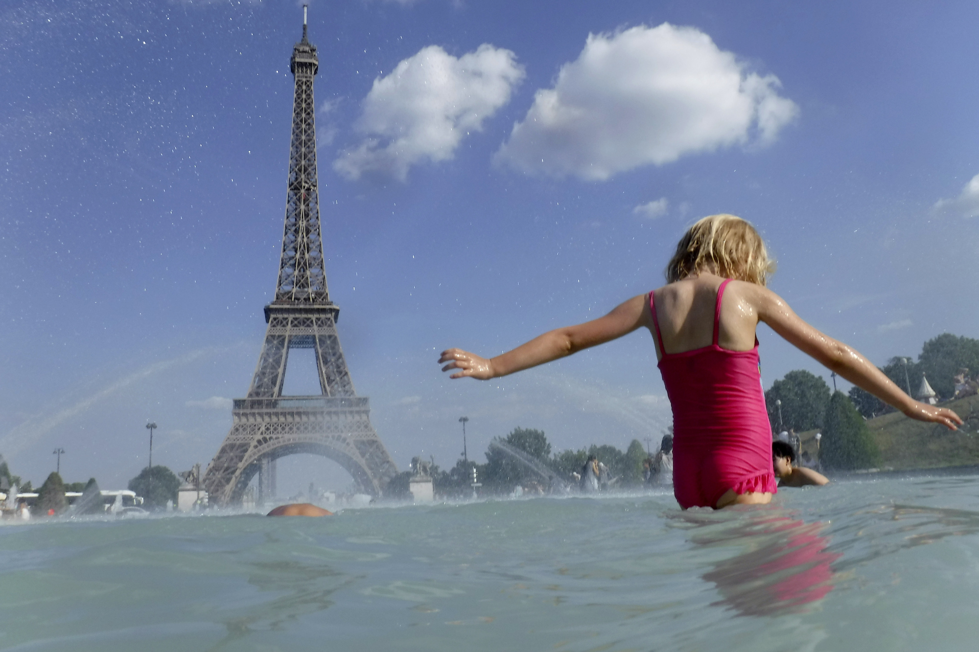 A girl cools off in the fountain of the Trocadero in Paris Tuesday. Authorities warned that temperatures could top 40 degrees Celsius (104 Fahrenheit) in some parts of Europe over the coming days, the effect of hot air moving northward from Africa. | AP